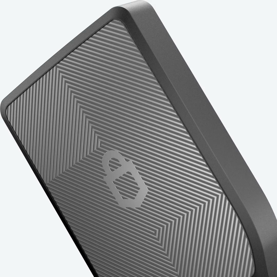 Black Trezor hardware wallet rotating to reveal its screen and textured back