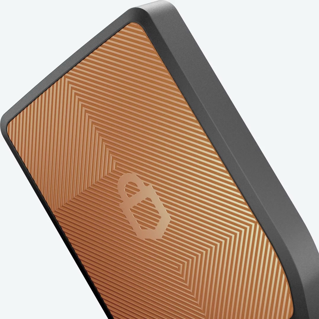 Orange Trezor hardware wallet rotating to reveal its screen and textured back