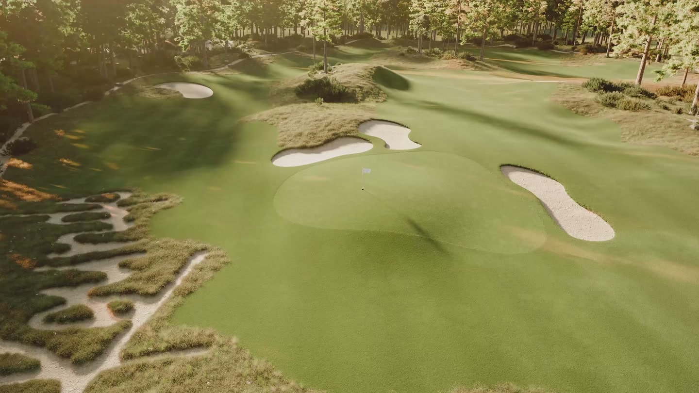 Aerial view across the golf course with sculpted greens, bunkers and surrounding trees