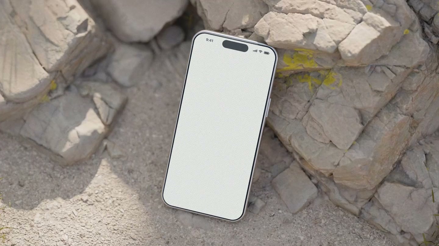 Rounds mobile app on a phone resting among sunlit rocks beside the course