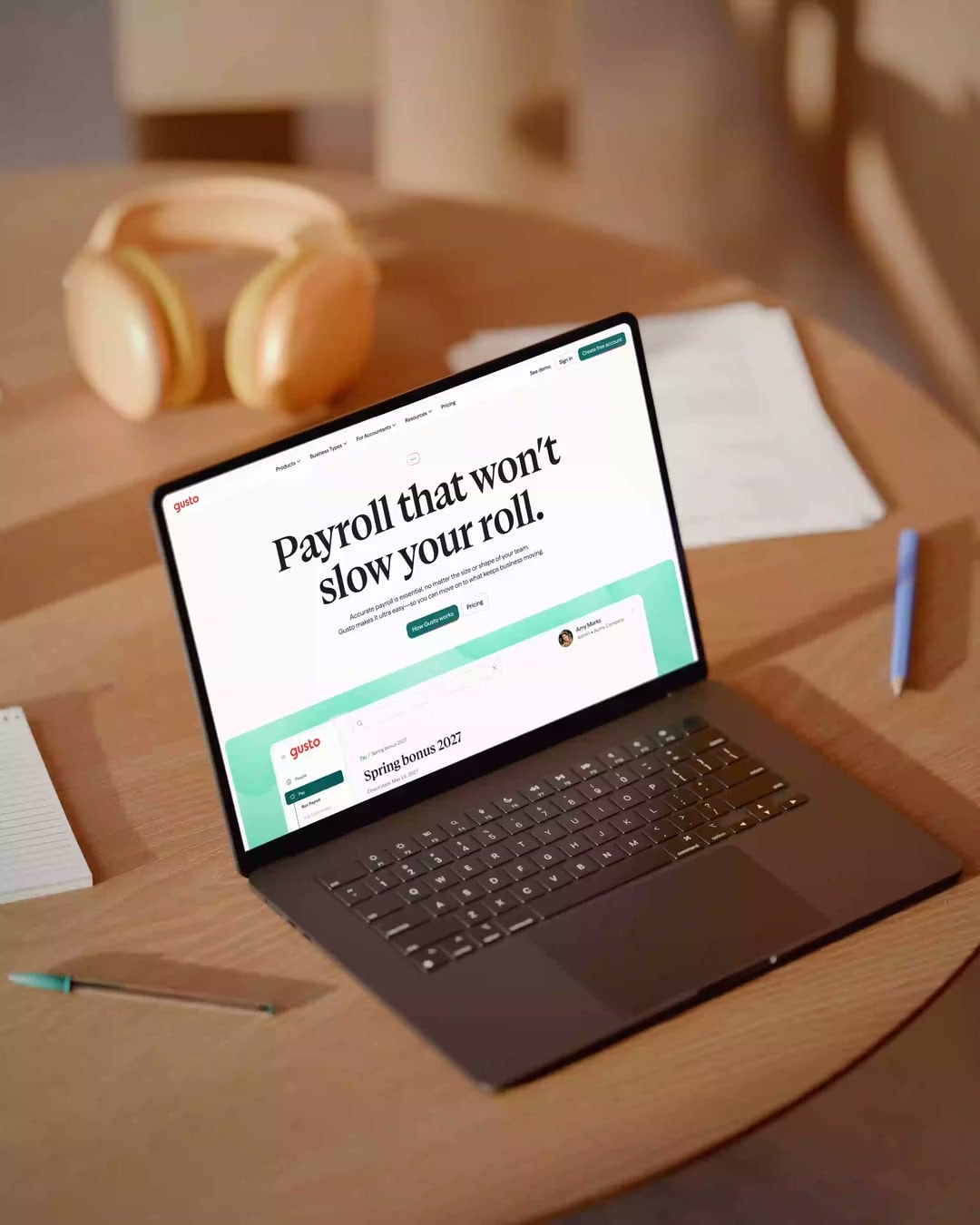 Gusto website on a MacBook in a warmly lit workspace